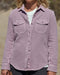 Woman wearing a pastel pink blanket shirt on the beach.